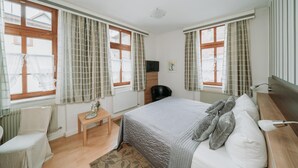 A bedroom with a bed, a desk, a chair, and a radiator. - Fränkischer  Gasthof  Hotel Zum Koppen (Gemuenden)