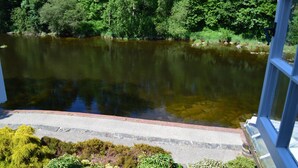 A river with a stone border and lush greenery in the background. - Pwll-y-Faedda (Builth Wells)