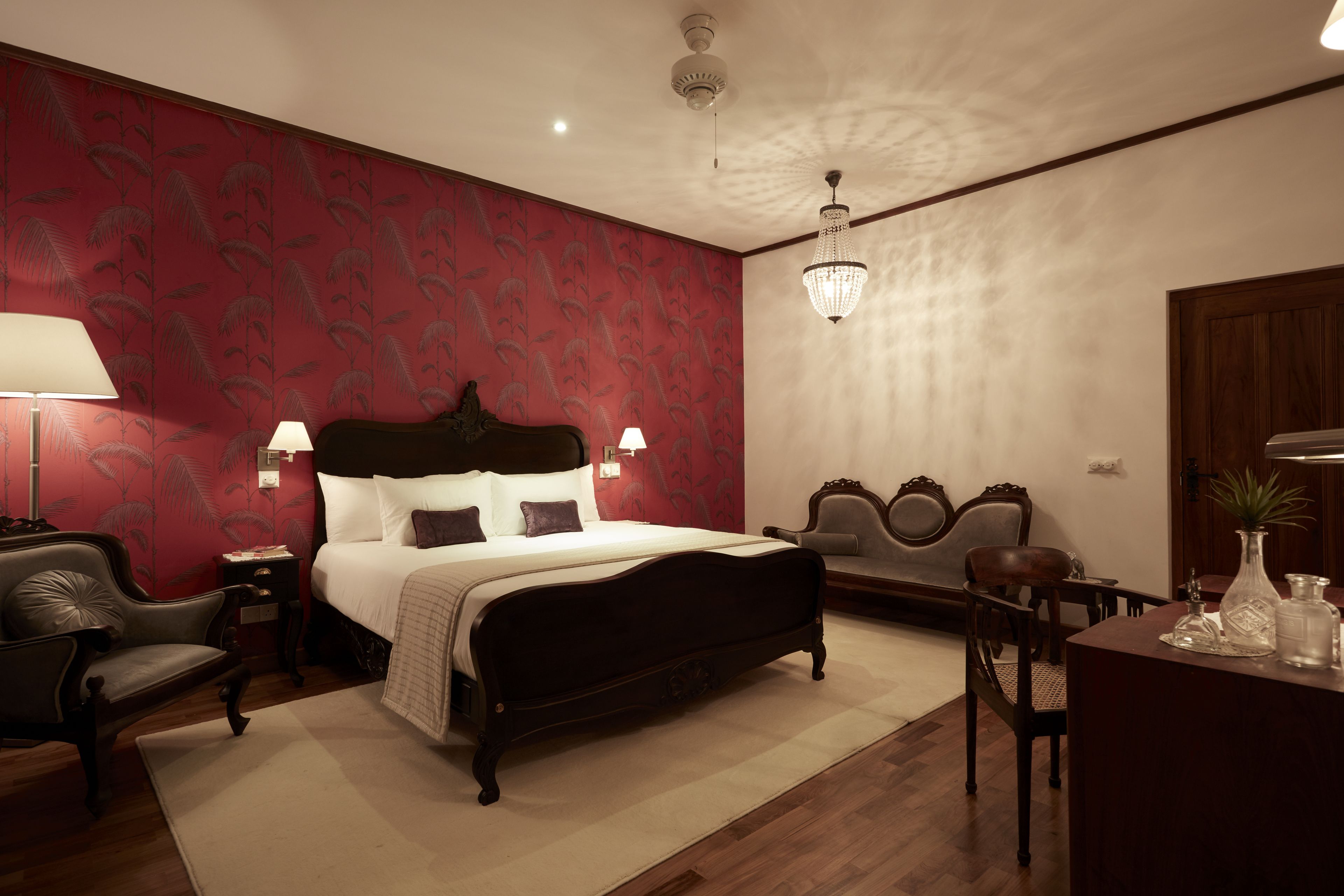 Une chambre à coucher avec un grand lit, deux tables de chevet, un bureau et une chaise.