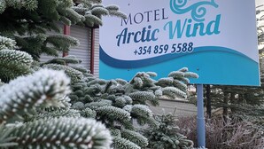 Un letrero de motel con el nombre 'Arctic Wind' y un número de teléfono.