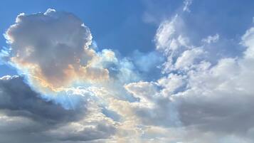 A landscape with a large cloud formation and a waterfall.