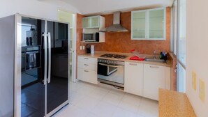 A modern kitchen with a built-in oven, microwave, and stainless steel range hood. - Capitalia | Renovated 2BR in Santa Fe’s Heart (Ciudad de México)