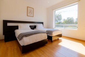 2 habitaciones, escritorio y tabla de planchar con plancha