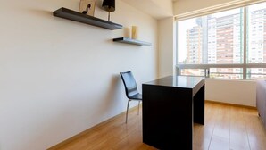 A modern room with a black table, a black chair, and two floating shelves with decorative items. - Capitalia | Renovated 2BR in Santa Fe’s Heart (Ciudad de México)