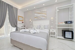 Een moderne hotelkamer met een groot bed, een inloopkast en een nachtkastje met een lamp.