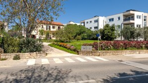 A residential area with modern and traditional buildings, a crosswalk, and well-maintained gardens. - Apartment Ivo (Rovinj)
