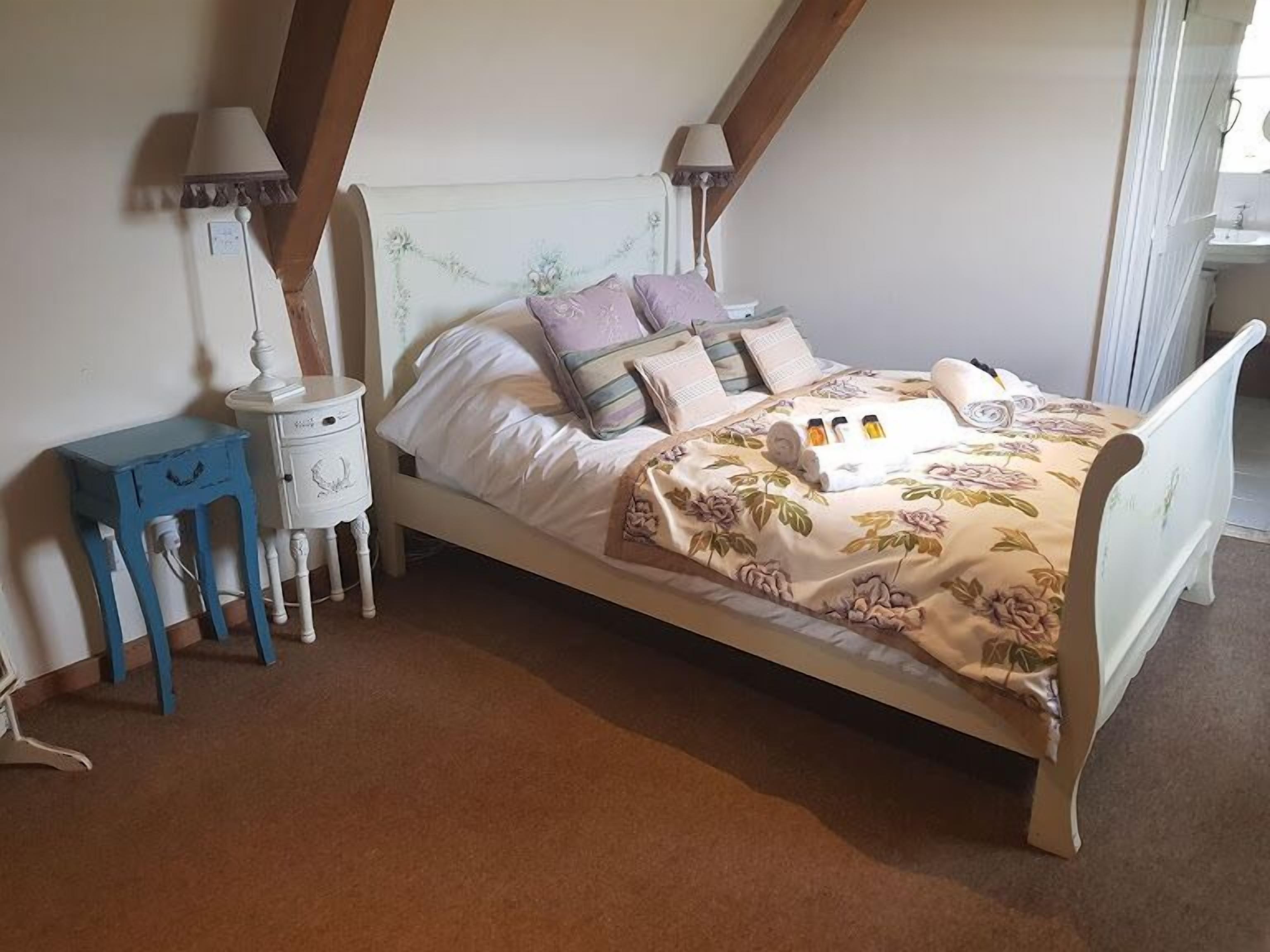Ein Schlafzimmer mit Bett, Nachttischen und einem Beistelltisch.