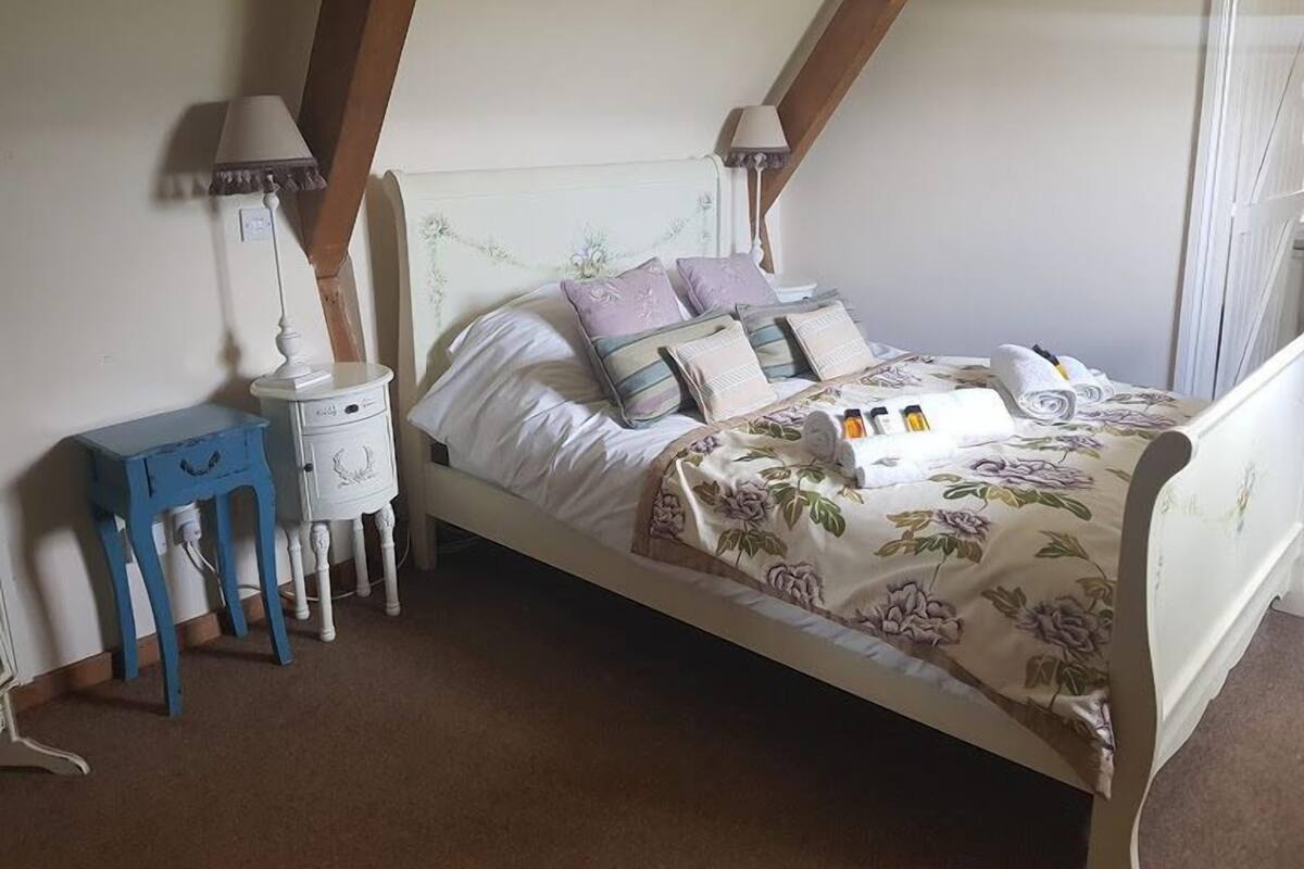 Un dormitorio con cama, mesitas de noche y una lámpara.