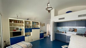 Une cuisine compacte avec un coin repas, un lit et un petit espace salon.