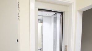 A hallway with a white door leading to a room with a white ceiling and walls. - Dolphin Court Gozo (Zebbug)