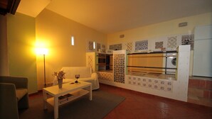Un espace de vie compact comprenant un canapé, une table basse, une lampe et un lave-linge.