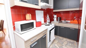 Una cocina compacta equipada con microondas, tostadora y estufa.