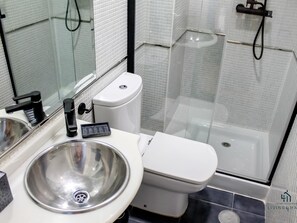 A modern bathroom with a sink, toilet, and glass-enclosed shower. - Spring Boutique Apartment Living4malaga (Málaga)