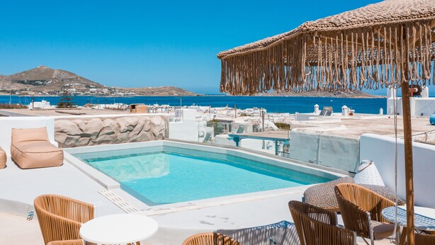 A rooftop pool area with a clear view of the sea and a mountain in the background. - Bohemian Luxury Boutique Hotel - Adults Only (Paros)