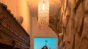 A corridor with a textured wall and a hanging light fixture. - Bohemian Luxury Boutique Hotel - Adults Only (Paros)