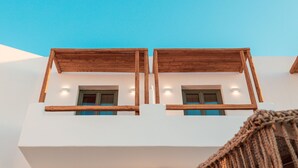 A modern building with two balconies, each with wooden railings and a small window. - Bohemian Luxury Boutique Hotel - Adults Only (Paros)