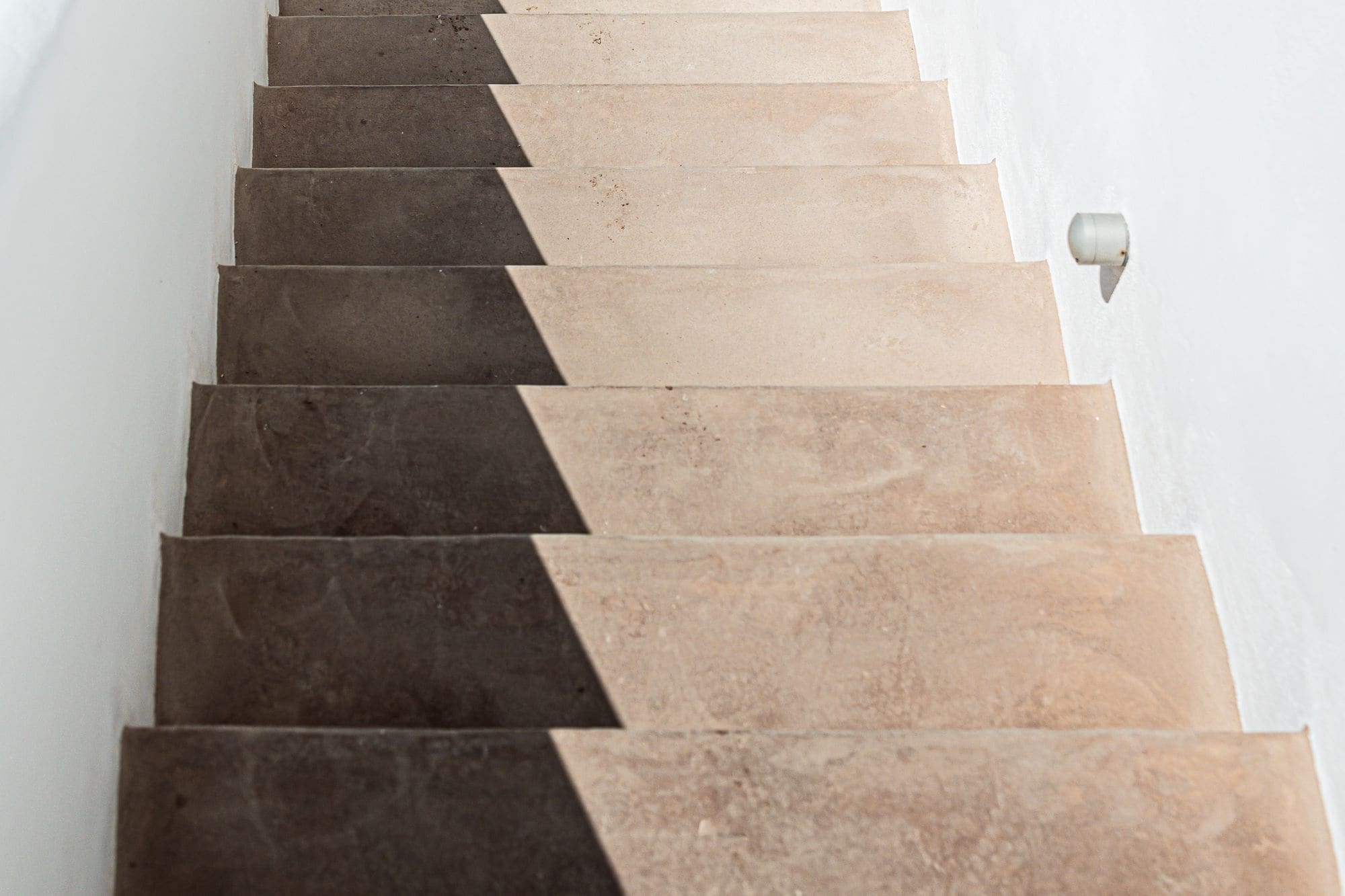 A staircase with alternating dark and light tiles.
