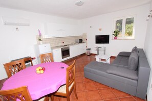 Un espacio habitable compacto con comedor, kitchenette y zona de estar.