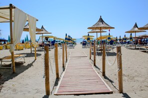 Plage privée, sable blanc, chaises longues, parasols