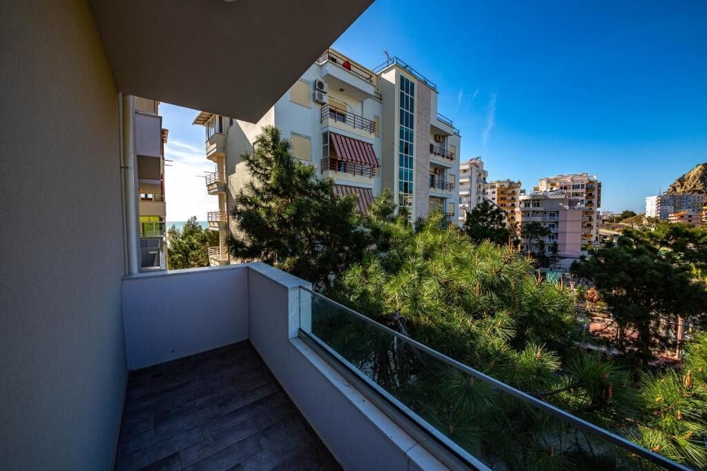 A balcony with a view of surrounding buildings and trees.