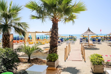 Playa privada, arena blanca, sillas reclinables de playa, sombrillas. Hotel Bella Vista