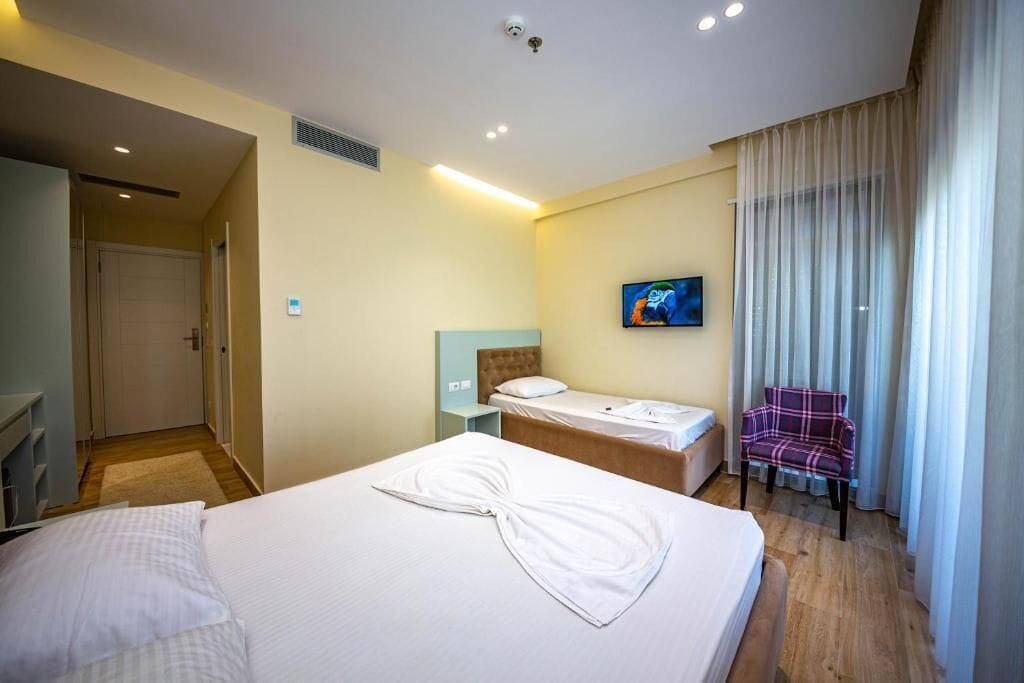 Chambre Triple, balcon, vue partielle sur la mer | 1 chambre, coffres-forts dans les chambres, bureau, rideaux occultants