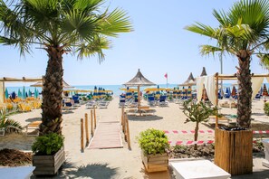 Plage privée, sable blanc, chaises longues, parasols