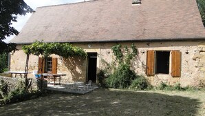 A rustic stone building with a tiled roof, a wooden door, and a small window with shutters. - 2 Beautiful country houses fully restored - stunning view                 (Dordogne)