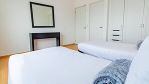 Une chambre à coucher avec un lit, une table de chevet, un miroir et une armoire.