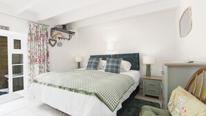 Een slaapkamer met een bed, nachtkastjes, een stoel en een kledingkast.