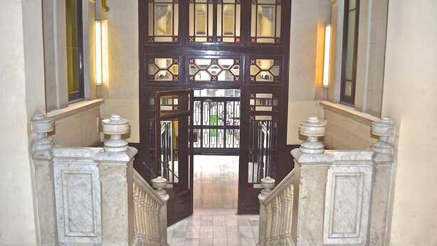 A grand entrance with a double door, a marble staircase, and wall sconces. - Exquisite designer 3BR Pg Gràcia apt - LaMimosa (Barcelona)