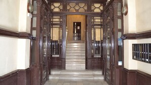 A grand staircase with ornate woodwork and glass panels, leading to an interior space. - Exquisite designer 3BR Pg Gràcia apt - LaMimosa (Barcelona)