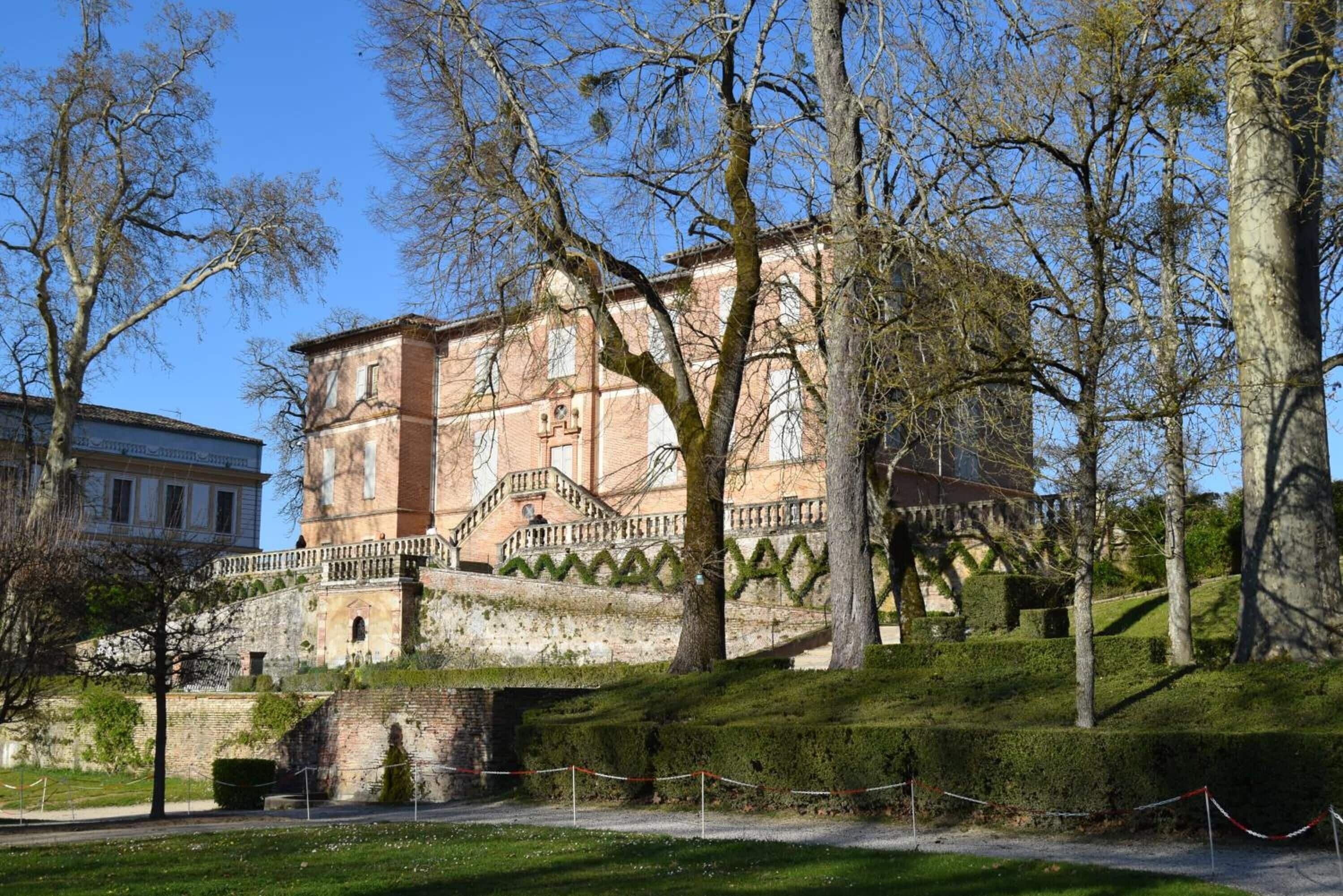 Un edificio histórico con una escalera destacada y un puente que lo conecta.