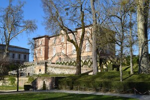 Un edificio histórico con una escalera destacada y un puente que lo conecta.