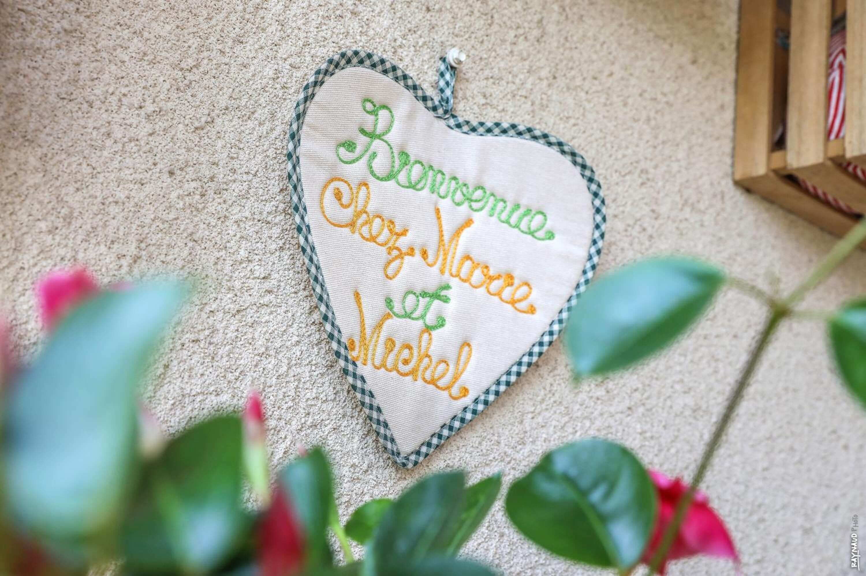 Tejido con forma de corazón y texto bordado.