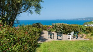 Eine Terrasse mit Sitzgelegenheit und Blick auf die Küste.