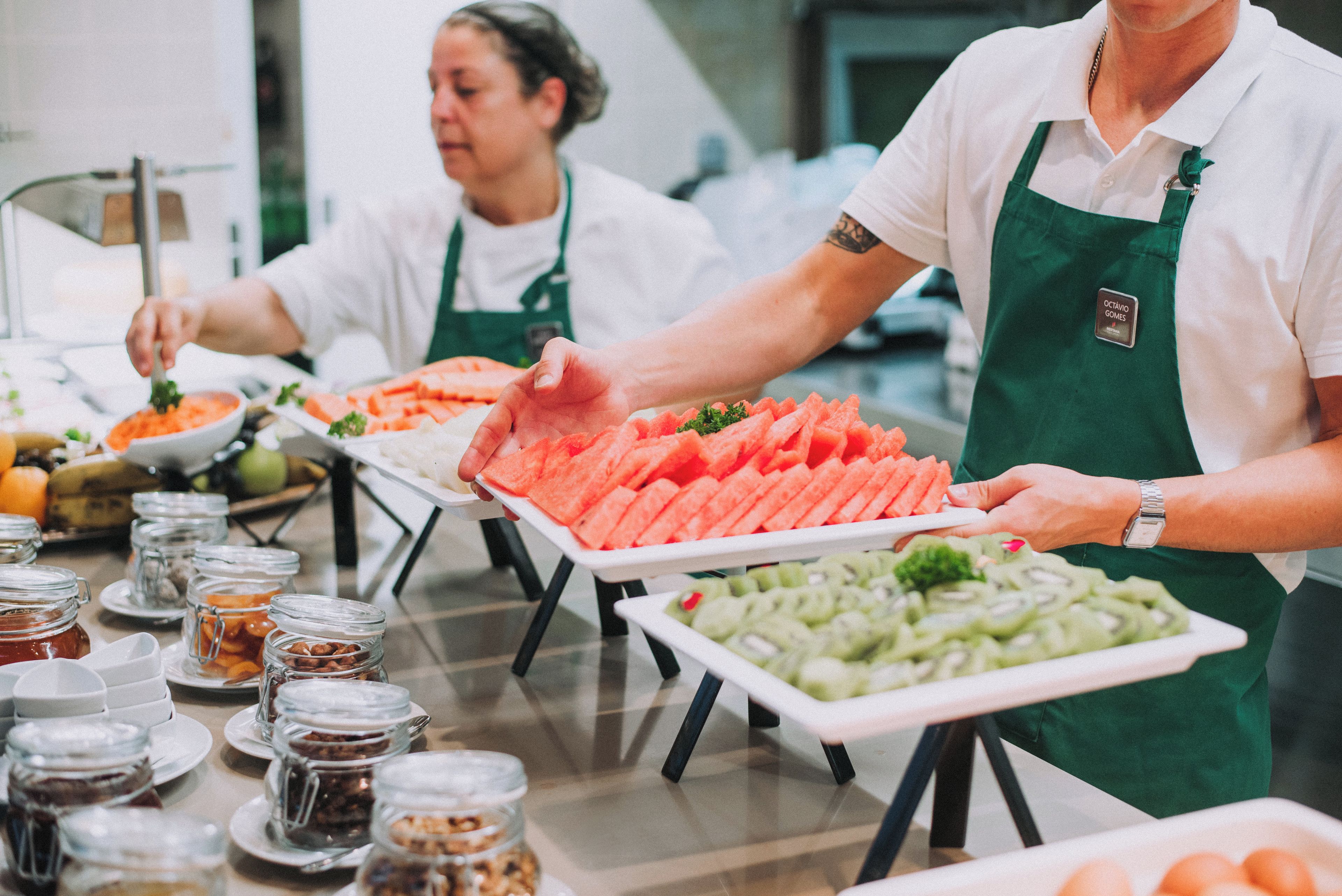 Montaje de bufé con diversos alimentos y personal de servicio.