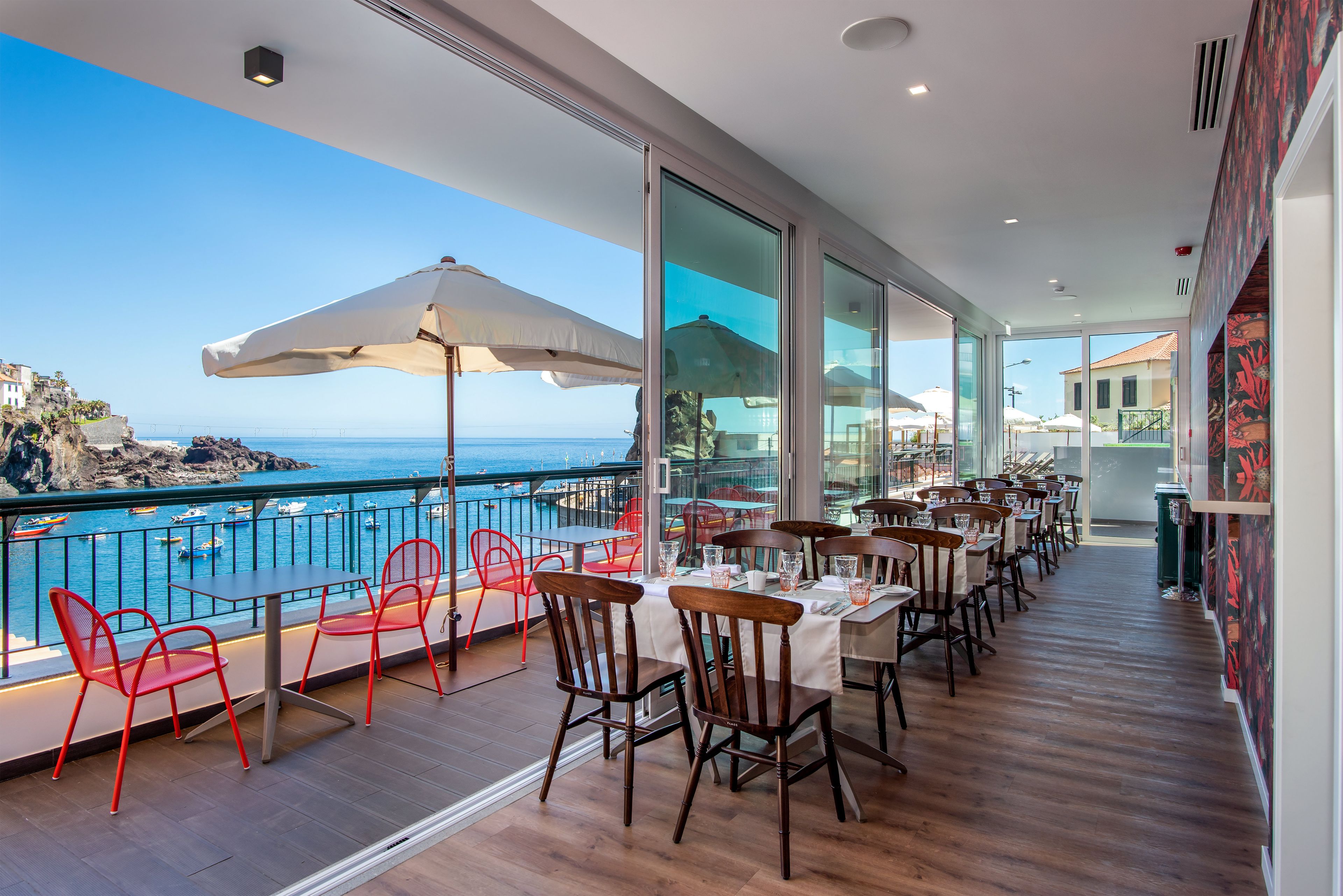 Restaurante com área externa e vista para o litoral.