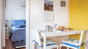 A bedroom with a bed, a desk, and chairs, a calendar, and a framed picture on the wall. - Anchors Away - One Bedroom Cottage, Sleeps 2 (Downderry)