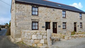 A stone building with two doors and windows, a paved driveway, and a stone wall. - Tom Thumb - One Bedroom Cottage, Sleeps 2 (Mabe Burnthouse)