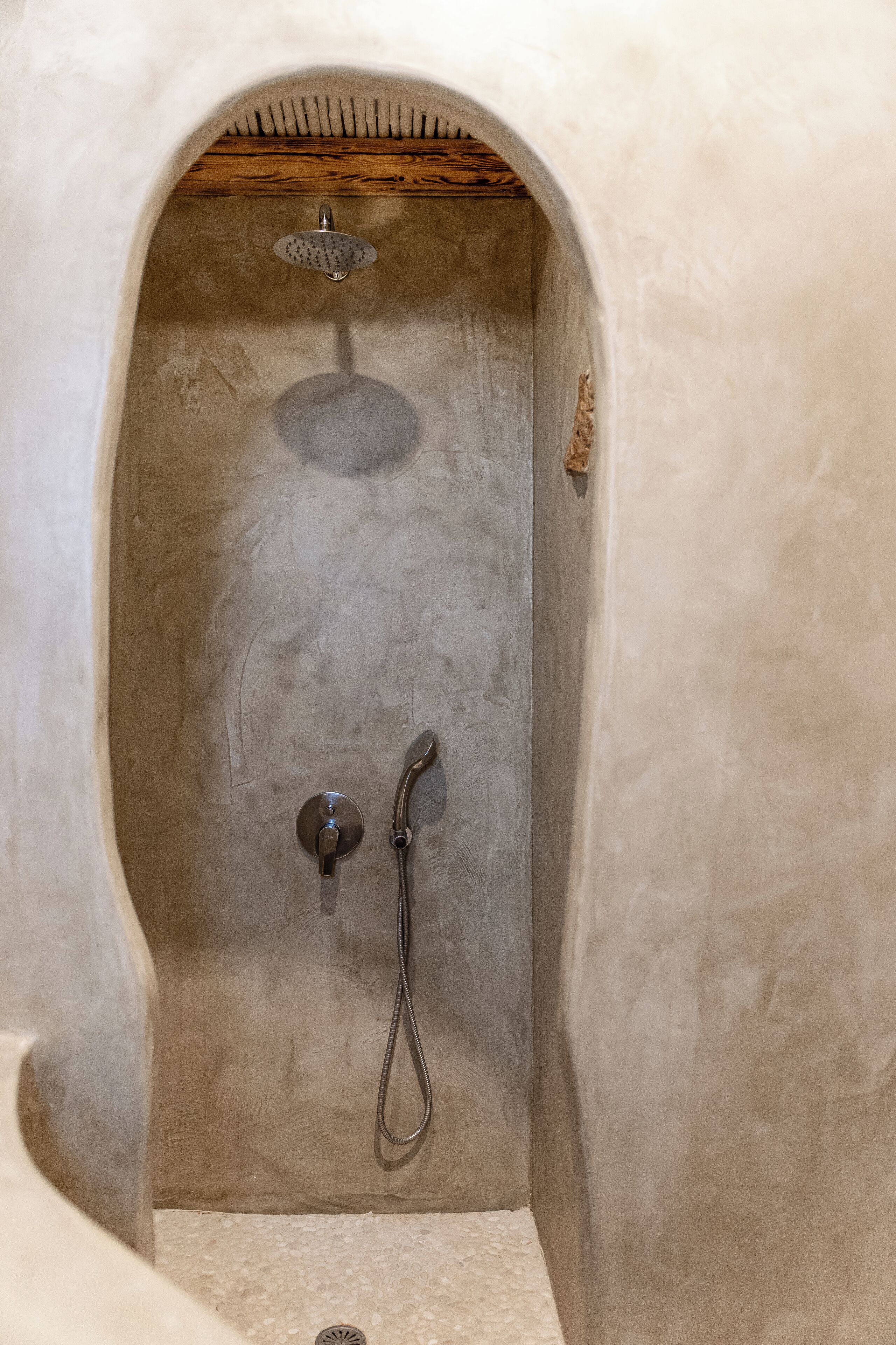 Un espace douche équipé d’un pommeau de douche et d’un flexible de douche.