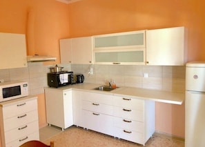 Departamento, 2 habitaciones | Cocina privada | Refrigerador, horno, parrilla de estufa y cafetera y tetera