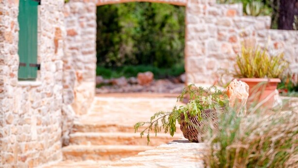 A stone archway leading to a building with a green door. - Stunning Renovated Traditional Stone Villa, Private Pool & Mountain Views just 800 m from the Sea! (Stari Grad)