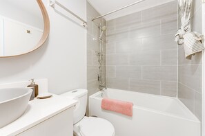 Combined shower/tub, hair dryer, towels, soap - The House of Blond penthouse level suite in LoLo (North Vancouver)