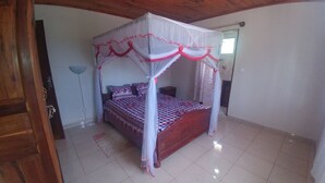 Ein Schlafzimmer mit Himmelbett, Nachttisch und einer Wandlampe.