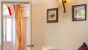 A living room with a light blue sofa, a white doormat, and two framed pictures on the wall. - Providence House - Four Bedroom Cottage, Sleeps 8 (Saint Breward)