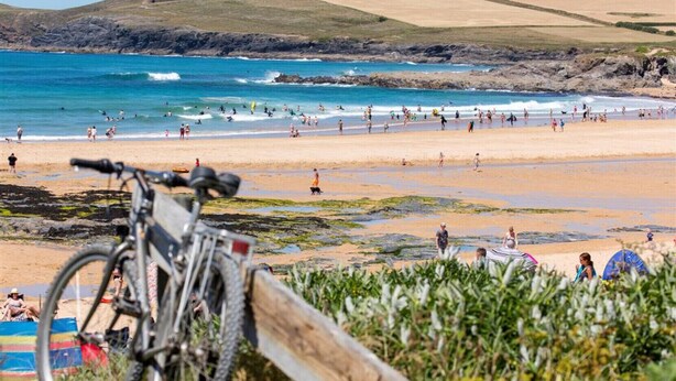 A beach with a bicycle leaning against a wooden post, surrounded by greenery. - Providence House - Four Bedroom Cottage, Sleeps 8 (Saint Breward)