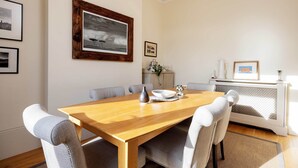 A dining area with a wooden table, six chairs, and a fireplace.