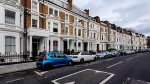 A row of terraced houses with a clear road in front. - Sinclair Sophistication, by Veeve (London)