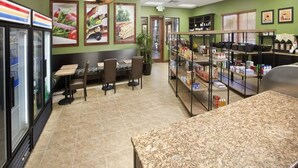Un restaurante con mostrador, zona de comedor y exhibición de alimentos.
